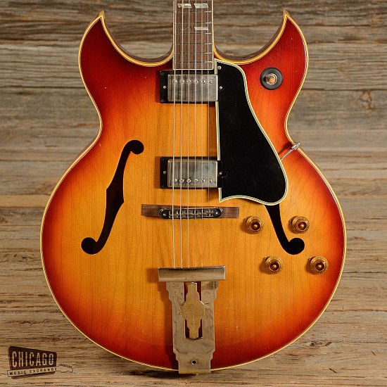GIBSON Guitars, Barney Kessel (Sunburst), 1963
Maple body; Mahogany neck; Rosewood fretboard
Body: Hollow maple (marked 2nd, serial number dates to 1963)
Neck: Mahogany neck with a medium-round profile, 1 11/16â€ wide nut, rosewood fretboard, 12â€ radius, and split parallelogram inlays
Pickups/Hardware: Kluson Deluxe tuners, two humbuckers (Rated at 7.6kOhms in the neck and 8.0k in the bridge), three-way pickup selector switch, independent volume and tone controls
Cosmetic Condition: The finish has a lot of heavy checking throughout the entire guitar as well as some normal play wear. For itâ€™s age, the body looks very clean with only some light dings and blemishes here and there. Most of the hardware and electronics are repro parts but the finish is all original and has a great vintage look. The neck has more checking lines that run the entire length all the way up the headstock. Checking lines aside, the neck and headstock are both very clean and free of any major dings or damage. This Barney Kessel is in amazing shape!
Playability: The strings are low, play great, and ring out clearly across the board.
Modifications/Repairs: Repro kluson tuners, refret, repro switch, Burstbucker pro pickups, repro guard, repro knobs, repro bridge, L-5 tailpiece, repro wiring harness, repro jack
Weight: 7lbs 4oz
Case: Non-original hardshell
Product Specs 
Condition: Very good
Make: Gibson 
Model: Barney Kessel
Finish: Sunburst
Categories: Vintage (pre-1980), Hollow Body
Year: 1963
Made In: United States
G-GIBSON-002
Sold
Location: Linebreak Above this text
DATE ADDED (DA): 2/6/2015
APPRAISAL VALUE (DA): $10,000.00
User5: $0.00
User6: $0.00